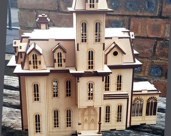 May include: A wooden model of a Victorian-style house with a brown roof, white walls, and multiple windows. The house has a front porch with a double door and a small staircase leading up to it.