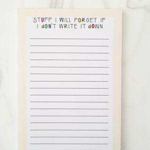 May include: A white notepad with black lines and the text "STUFF I WILL FORGET IF I DON'T WRITE IT DOWN" in colorful letters.
