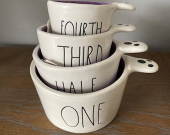 Rae Dunn Halloween Measuring Cup Set: Ghost Shaped. all white and purple interior.