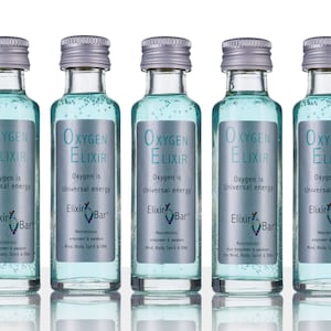 Puede incluir: Cinco pequeñas botellas de vidrio con tapas plateadas llenas de un líquido azul claro. Cada botella tiene una etiqueta que dice "Oxygen Elixir" y "Oxygen is Universal Energy". La etiqueta también incluye el texto "Elixir Bar" y un eslogan sobre neurotónicos.