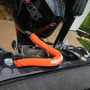May include: Orange motor guard with the word "Motor" printed on it. The guard is attached to a black boat motor with the words "Mercury Pro XS" printed on the side.