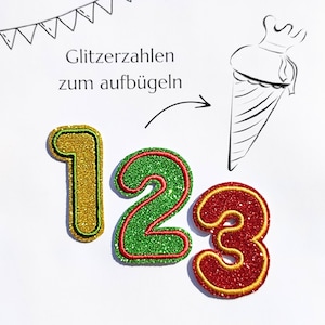 Könnte beinhalten: Glitzernde Aufbügelzahlen 1, 2 und 3 in Gold, Grün und Rot mit Glitzereffekt. Jede Zahl hat einen kontrastierenden Rand. Das Bild enthält auch den Text "Glitzerzahlen zum aufbügeln" und eine Strichzeichnung einer Schultüte.