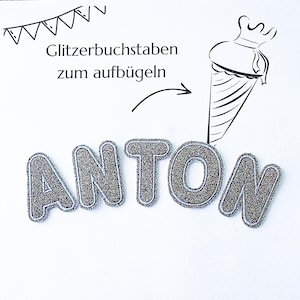 Könnte beinhalten: Glitzernde silberne Buchstaben mit der Aufschrift "ANTON" mit weißem Umriss, zum Aufbügeln auf Stoff. Das Bild enthält eine Skizze eines Eisbechers und den Text: "Glitzerbuchstaben zum aufbügeln."