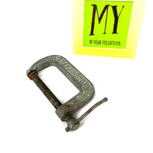 May include: A silver metal C-clamp with a threaded screw and a handle. The clamp is labeled "STEELCRAFT".