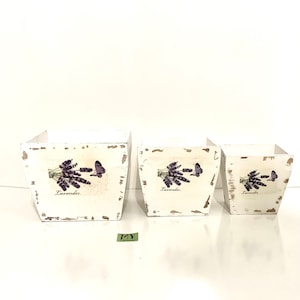 May include: Three white wooden planter boxes with a distressed finish. Each box features a lavender flower and butterfly design with the word "Lavender" printed on the front.
