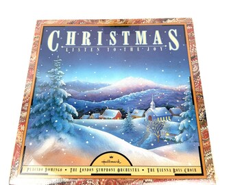 May include: A Christmas album cover featuring a winter landscape with snow-covered trees and a church. The title "CHRISTMAS" is displayed in large, white letters above the text "LISTEN TO THE JOY". The Hallmark logo is visible.