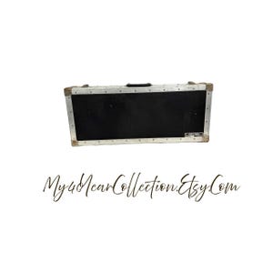 May include: A rectangular black case with silver metal trim and a black handle. The case has a small label on the front. The words "My40YearCollection.Etsy.Com" are written in cursive below the case.