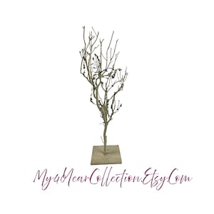 May include: A decorative tree made of branches with a square base. The tree is decorated with small brown beads. The tree is on a white background.