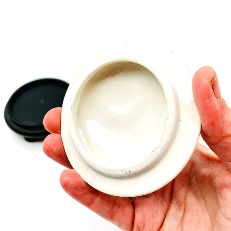 May include: White ceramic lid with a smooth, glossy finish. The lid is round and has a slightly raised edge.