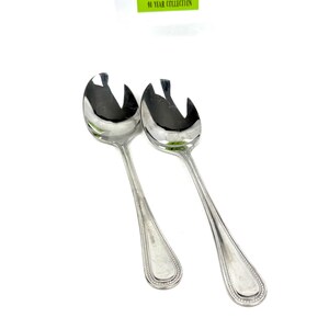 May include: Two shiny, silver serving spoons with a unique slotted design. The spoons have long, slender handles with a beaded border and a teardrop-shaped end. The image includes a green and white tag that reads "MY 10 YEAR COLLECTION."