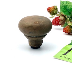 以下が含まれることがあります： 丸みを帯びたトップとベースの周りに装飾的なリングが付いた、ビンテージの真鍮製のドアノブ。ノブはわずかにくすんでおり、摩耗した仕上げになっています。