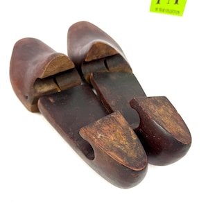 Pair of vintage wooden shoe stretchers angled with rich patina