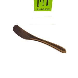 May include: A wooden butter knife with a dark brown wood handle and a lighter brown wood blade.