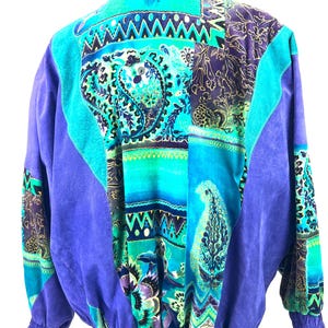 May include: A purple suede jacket with a colorful patchwork design featuring paisley patterns, geometric shapes, and floral motifs.