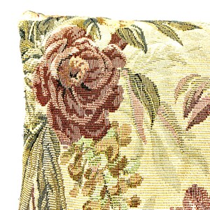 May include: A close-up of a decorative pillow with a floral pattern. The pillow is made of a woven fabric with a textured surface. The pattern features a large red rose with green leaves and a smaller floral design in the background.
