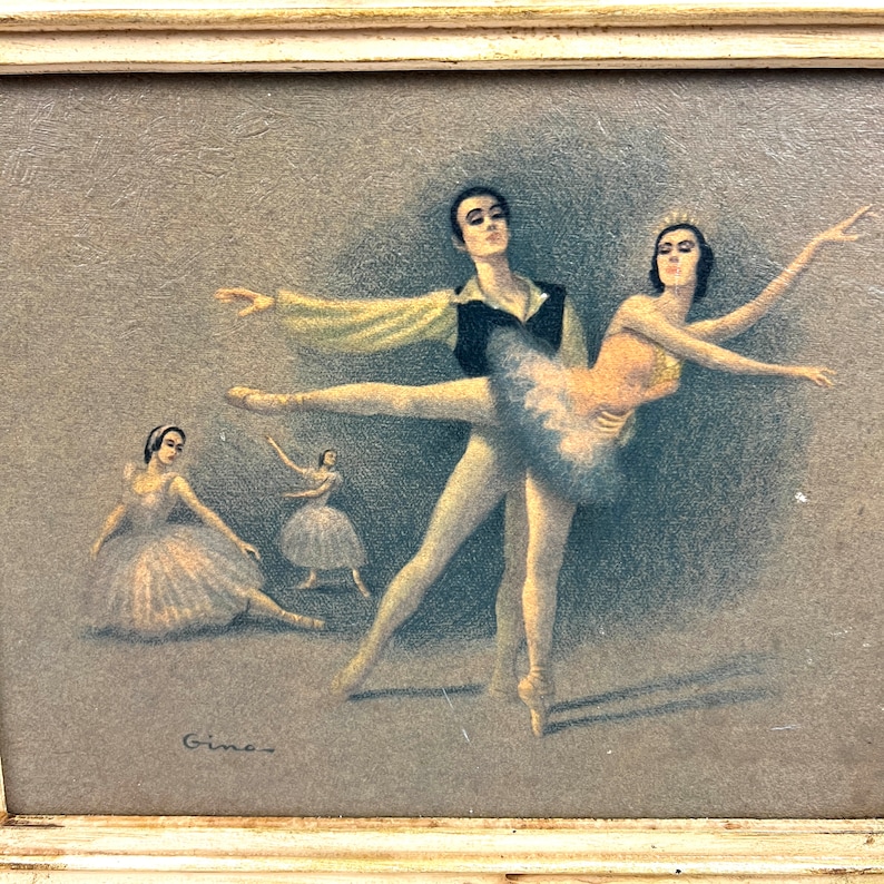 May include: A framed vintage print of a ballet performance. The print features four dancers in a light gray background. The dancers are wearing traditional ballet costumes. The print is signed "Gines" in the bottom left corner.