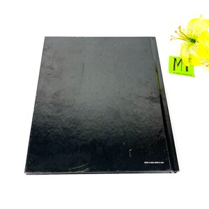May include: Black hardcover book with a smooth, glossy finish. The book has a white ISBN number on the bottom edge.