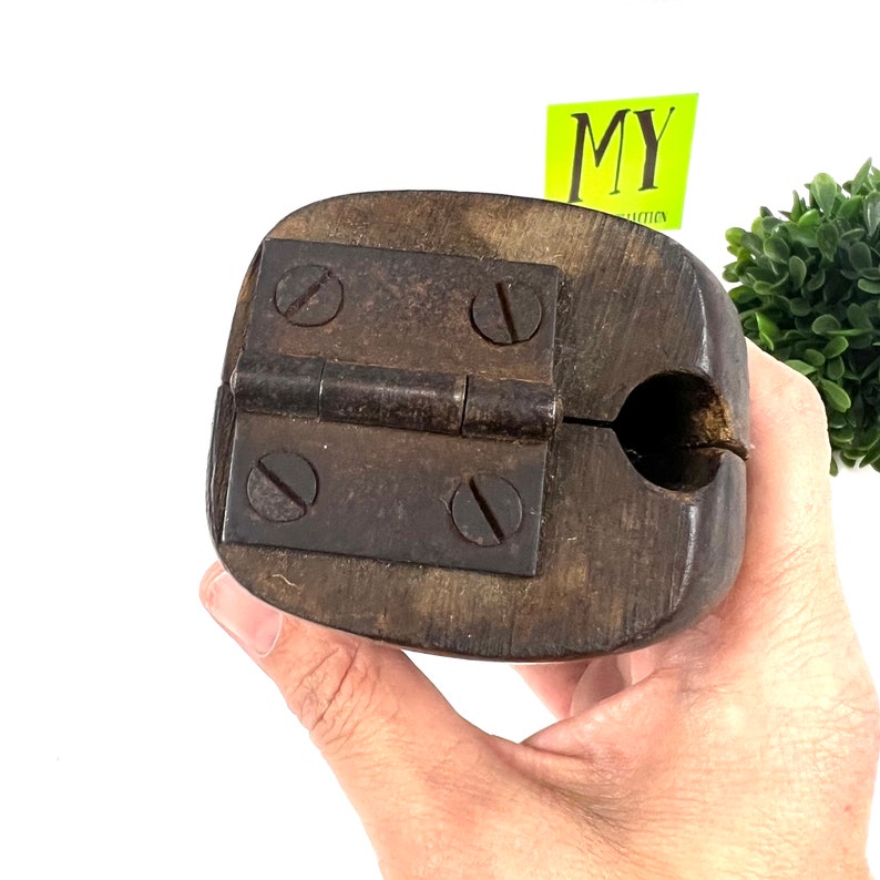 May include: A wooden tool with a metal hinge and four screws. The tool is open and has a round hole in the center.