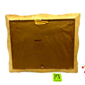 May include: The back of a framed picture with a brown paper backing. The frame is a light brown color with a decorative, scalloped edge. The paper backing has a sticker with the text "Celebration" and the number "416-771".