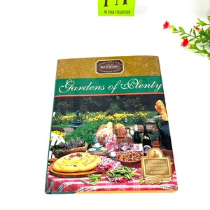 Puede incluir: Un libro de cocina titulado "Gardens of Plenty" de la serie de libros de cocina Gail Greco's Little Bed & Breakfast. La portada presenta una escena de picnic con un mantel a cuadros, comida, vino y una cesta. El libro está avalado por la Cooking Association of Country Inns.