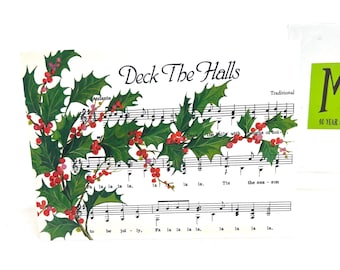 May include: Sheet music featuring the words "Deck The Halls" and musical notation. The page is adorned with illustrations of green holly leaves and red berries. The word "Traditional" is printed above the musical notes.