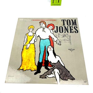 Puede incluir: Portada de &aacute;lbum de vinilo vintage de "Tom Jones" con una ilustraci&oacute;n estilizada de personajes teatrales. La portada tiene un fondo gris con el t&iacute;tulo en letras negras grandes y el nombre del artista.