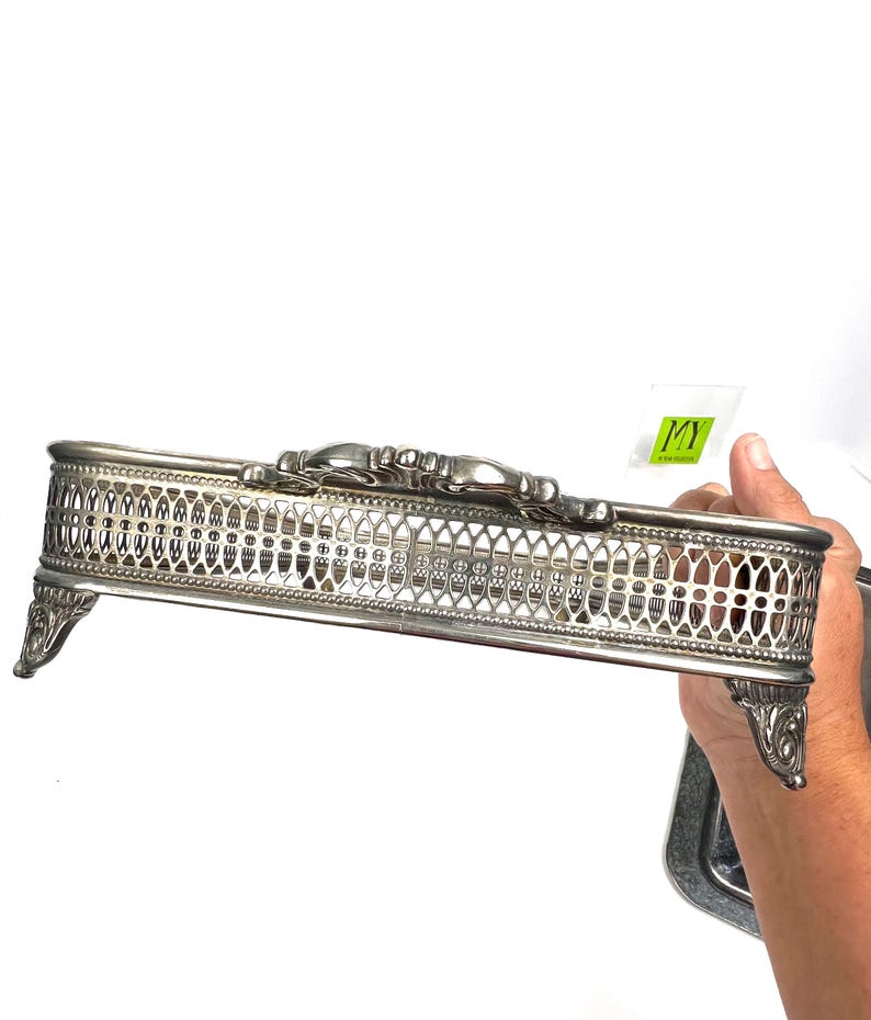 May include: Silver plated serving tray with an ornate design and four feet. The tray has a decorative, openwork design.