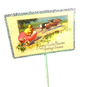 May include: Vintage Easter greeting card featuring a yellow chick in a red wagon pulled by two rabbits. The card has a decorative silver glitter border and text that reads "Joyous Easter Memories with Greetings Sincere."