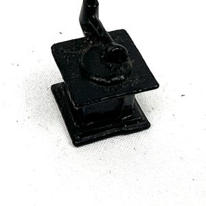 May include: A small, black cast iron stove with a single burner and a pipe for a chimney.