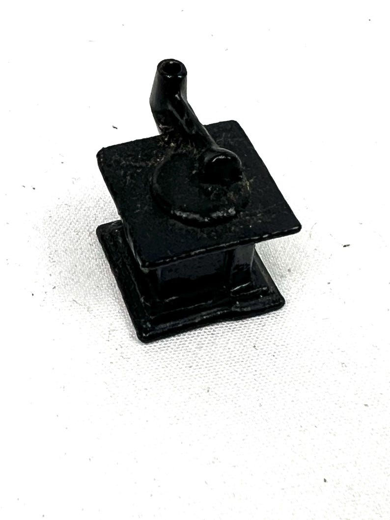 May include: A small, black cast iron stove with a single burner and a pipe for a chimney.