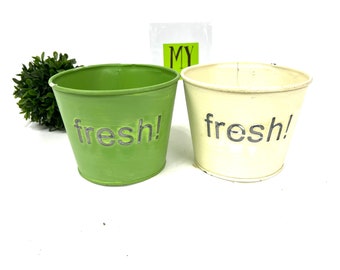Macetas metálicas vintage: Macetas verdes y crema con el lema "¡Frescura!"