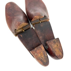 Pair of vintage wooden shoe stretchers angled with rich patina