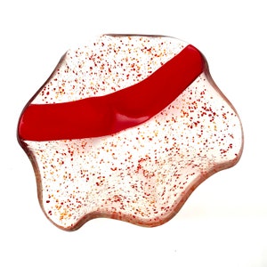 K&ouml;nnte beinhalten: Eine wei&szlig;e Glassch&uuml;ssel mit einem roten Streifen und einem gesprenkelten orange-wei&szlig;en Design.