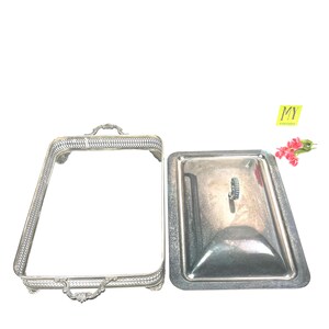 May include: Silver serving dish with a lid. The dish has a decorative border and a handle on the lid.