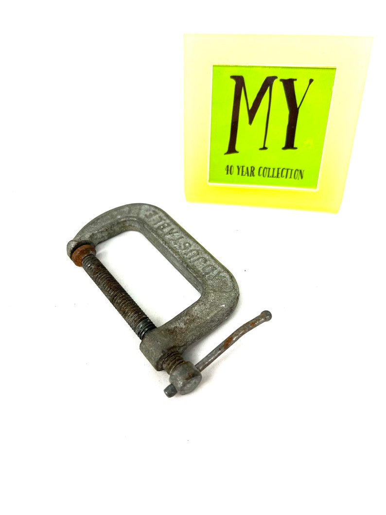 May include: A silver metal C-clamp with a threaded screw and a handle. The clamp is labeled "STEELCRAFT".