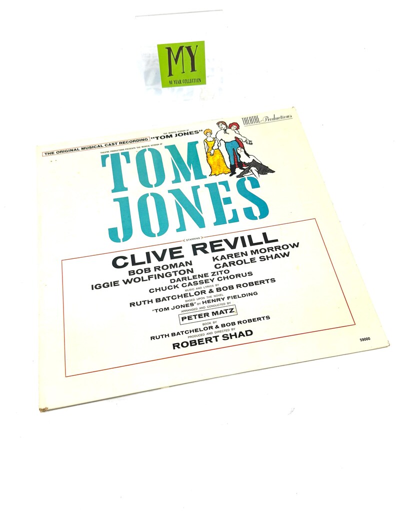 Puede incluir: Una portada de &aacute;lbum de vinilo vintage para "Tom Jones", con un t&iacute;tulo turquesa y los nombres del elenco. La portada incluye ilustraciones de personajes con vestuario de &eacute;poca. El &aacute;lbum es una grabaci&oacute;n musical.