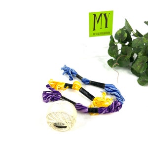 May include: A ball of white embroidery floss with three skeins of embroidery floss in purple, yellow, and blue. The skeins are labeled "MY 40 YEAR COLLECTION".