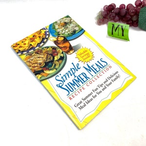 May include: A yellow cookbook with the title "Simple Summer Meals Recipe Collection" and a picture of grilled chicken and vegetables on the cover.