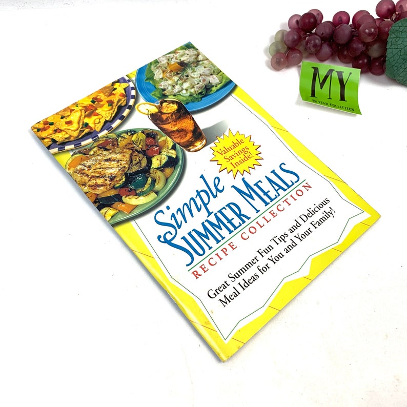 May include: A yellow cookbook with the title "Simple Summer Meals Recipe Collection" and a picture of grilled chicken and vegetables on the cover.