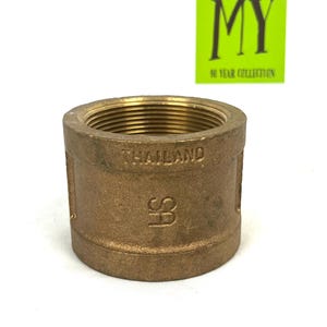 Puede incluir: Un accesorio de tubería de latón con un extremo roscado. El accesorio está etiquetado como "THAILAND" y tiene una marca "FS".