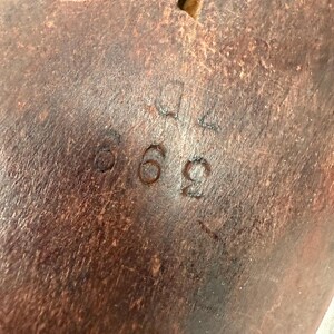 Bottom view showing wear, markings, and dark finish