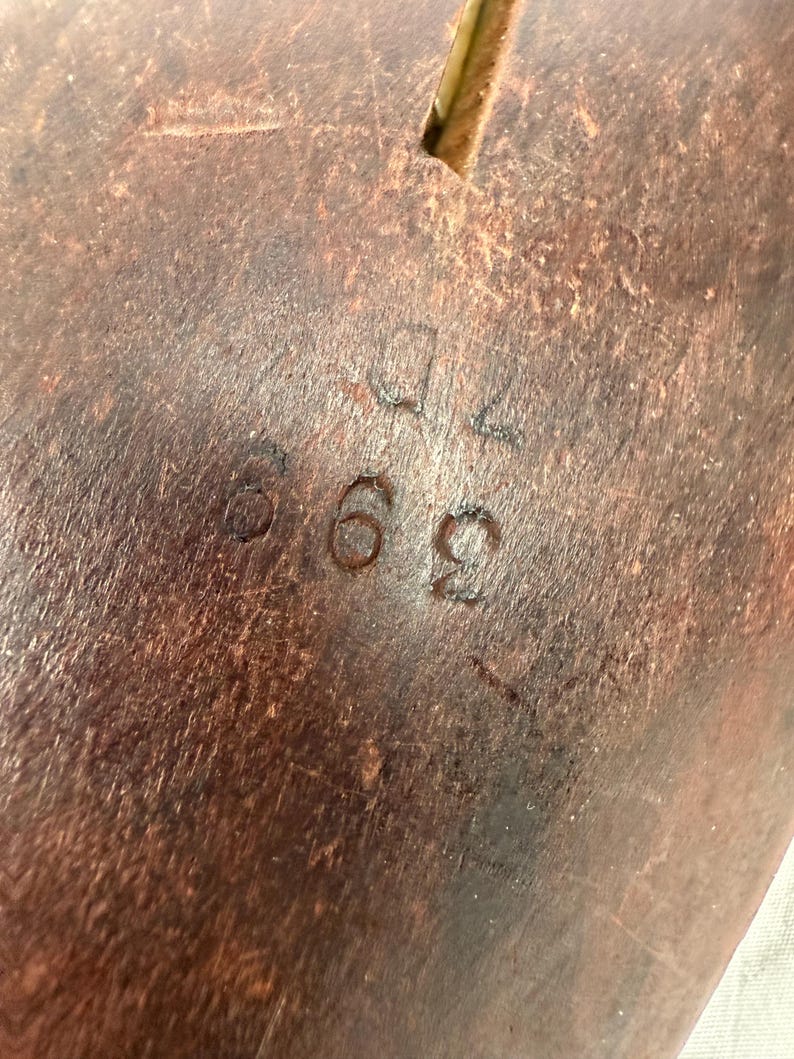 Bottom view showing wear, markings, and dark finish