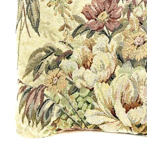 May include: A close-up of a tapestry fabric with a floral pattern in shades of green, brown, and yellow. The fabric has a textured woven look.