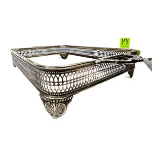 May include: Silver-plated serving tray with a decorative, openwork design and four ornate feet. The tray has a rectangular shape and a handle on one side.