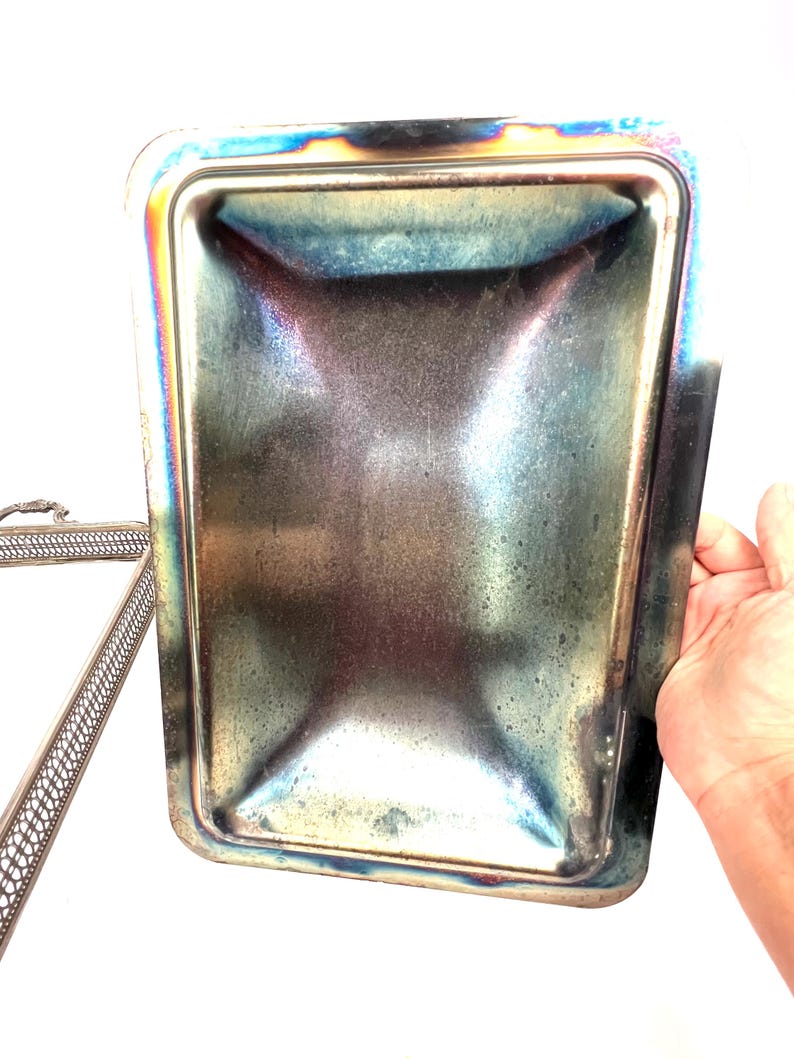 May include: Silver serving tray with a decorative, openwork design. The tray has a matching lid with a smooth, slightly concave interior.