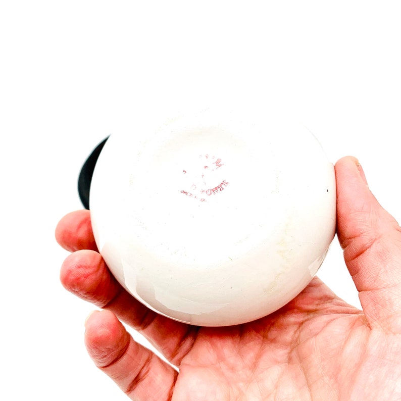 May include: White ceramic round bowl with a pink stamp on the bottom that reads "C.Z.W.T.E."