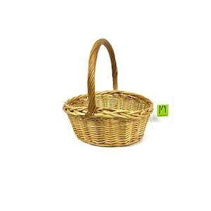 May include: A natural woven wicker basket with a single handle. The basket is oval shaped and has a light brown color.