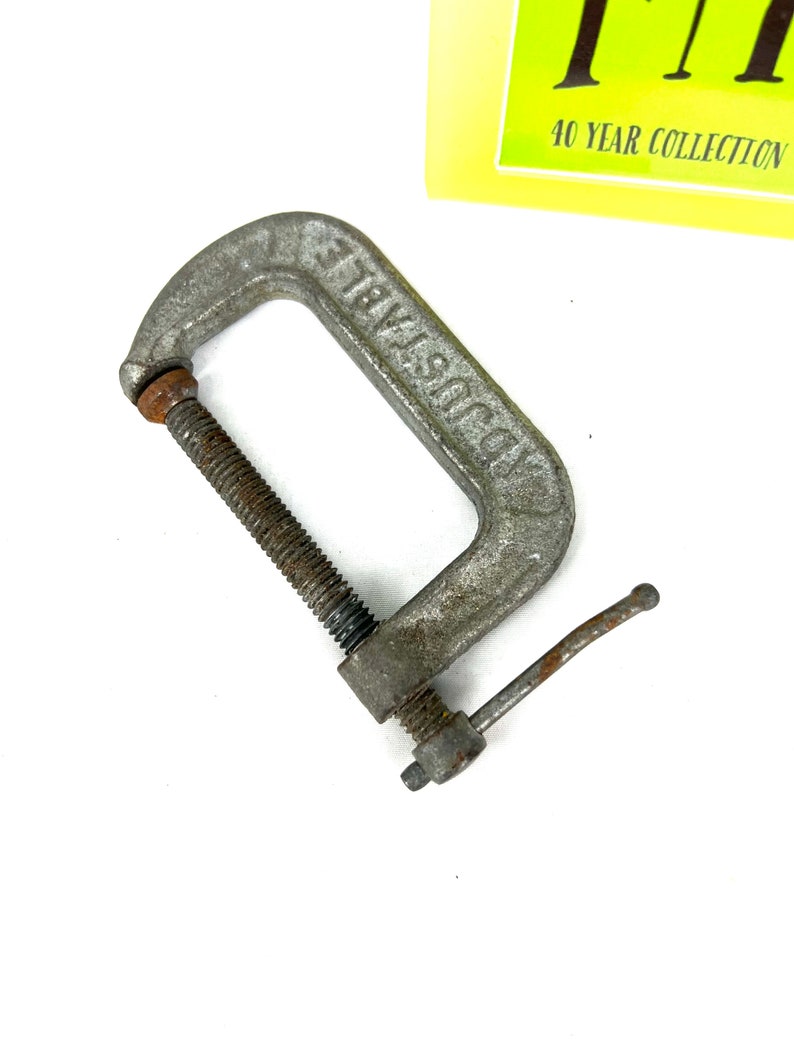 May include: A silver metal C-clamp with a threaded screw and a lever handle. The clamp is labeled "Industrial".