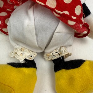 May include: A plush doll featuring a red and white polka dot dress, white bloomers with lace trim, and yellow shoes with black accents. The doll's design is reminiscent of a classic cartoon character.