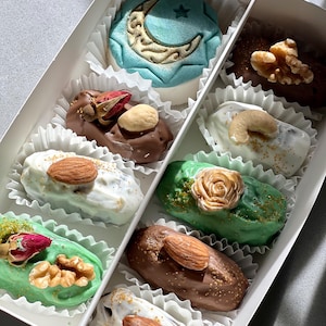 May include: A box of assorted chocolate-covered dates, some with almonds, some with walnuts, and some with a green mint coating. The box also includes a decorative moon and star cookie.
